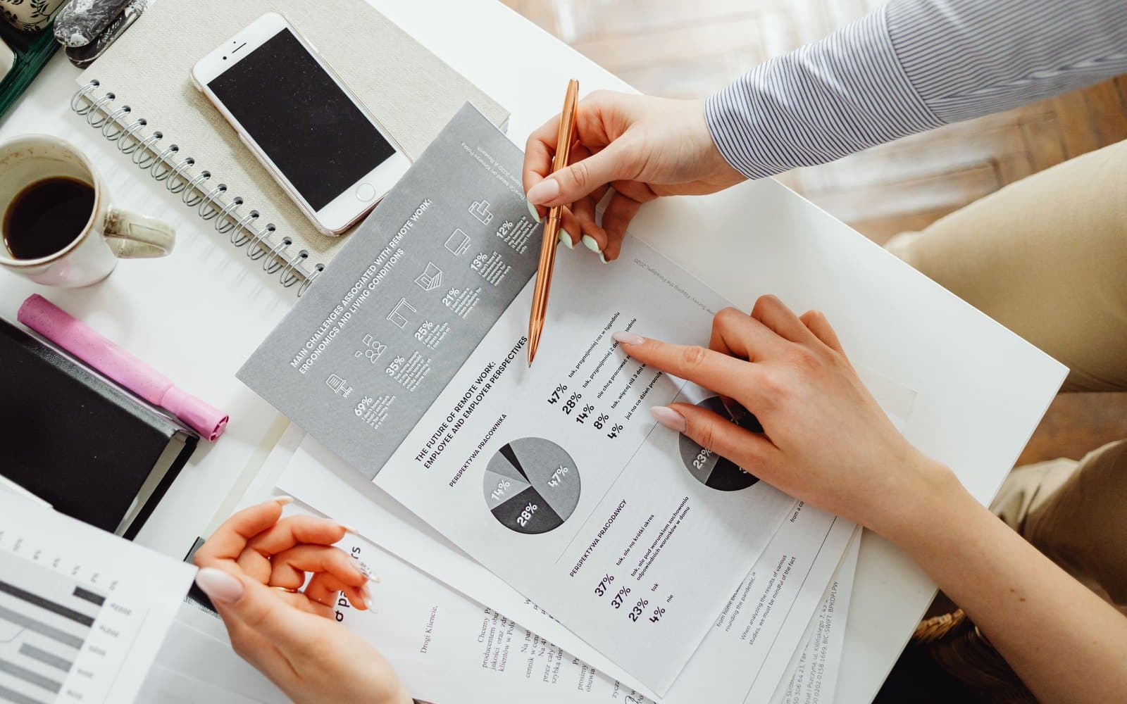 Hands reviewing figures and charts on a light desk